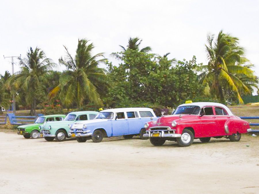 Taxis from the 50s wait on the beach - Spanish language courses